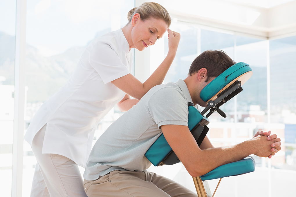 Man receiving chair massage therapy from EAP program.